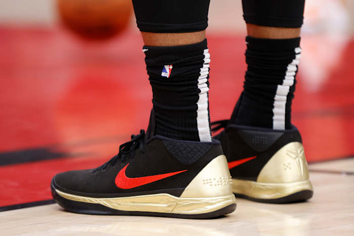 View of black, red, and gold Nike Kobe shoes.
